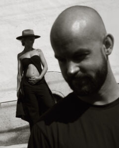 black and white editorial image of a couple standing juxtaposed in hard light pregnancy announcement maternity session in Oaxaca City mexico